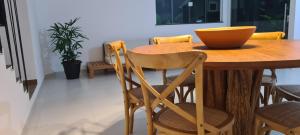 uma mesa de madeira com cadeiras e uma tigela sobre ela em Casa 22 Lençóis Maranhenses - Barreirinhas - MA em Barreirinhas