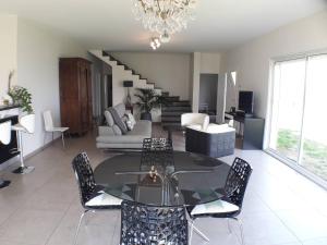 a living room with a glass table and chairs at 170 m² entre Lyon et St Etienne in Saint-Martin-la-Plaine
