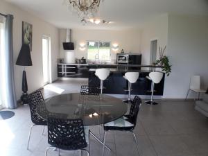 a dining room with a glass table and chairs at 170 m² entre Lyon et St Etienne in Saint-Martin-la-Plaine +4 photos