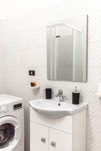 a bathroom with a sink and a washing machine at Cornigliano Apartment 2 in Genoa