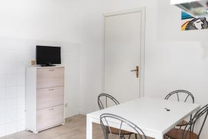 ein weißes Esszimmer mit einem weißen Tisch und Stühlen in der Unterkunft Cornigliano Apartment 2 in Genua