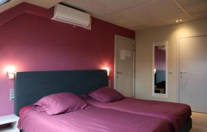 a bedroom with a large bed with purple sheets at A Casa in Nieuwpoort