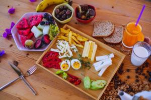 a wooden table with a tray of food with breakfast foods at Golden Lighthouse Hotel in Patara