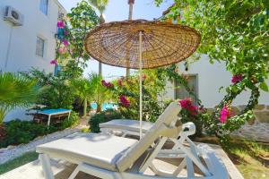 a chair and an umbrella and a chair and a table at Golden Lighthouse Hotel in Patara