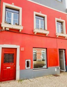 a red building with two windows and a red door at Casa Portas de Portugal in Lagos