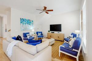 uma sala de estar com sofás azuis e uma televisão de ecrã plano em 51 Magical Place em Santa Rosa Beach