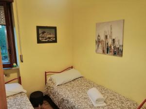 a bedroom with two beds and a picture on the wall at Elena Rooms in Campobasso
