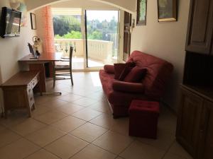 Villa Paradiso, logement avec piscine, Nice Nord في نيس: غرفة معيشة مع أريكة حمراء وطاولة