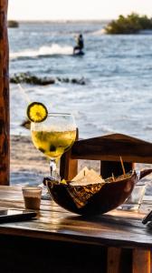 a drink sitting on a table by the beach at Villa Kabaceiras in Tatajuba