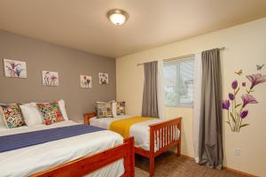 a bedroom with two beds and a window at Walk to Downtown Leavenworth * Sleeps 6 + Pets * Ground Level Gem! in Leavenworth