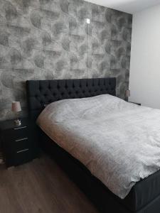 a bedroom with a bed and a stone wall at De Poldersteeg in Everdingen +7 photos