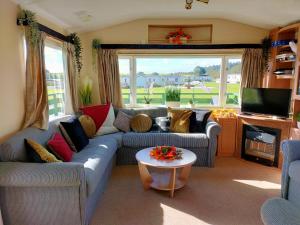 a living room with a couch and a table at 57 Peaceful Corner Caravan in Balminnoch