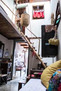 uma sala de estar com uma escada e cestos na parede em CASA DE RETALHOS Boutique Albergue, casaril histórico, com 5 suítes individuais e cozinha coletiva, no coração da vila de Igatu-Ba, que preserva fortes traços culturais da época do garimpo, venha viver uma experiência única! em Igatu