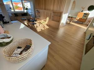 a living room with a white counter and wooden floors at Le dodo mauricien in Wimereux