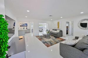 a white living room with a couch and a table at Salt Life Beach Cottage Sleeps 8 Heated Pool in Pompano Beach
