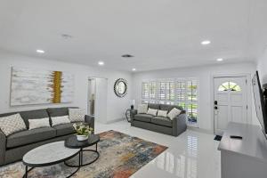 a living room with a couch and a table at Salt Life Beach Cottage Sleeps 8 Heated Pool in Pompano Beach