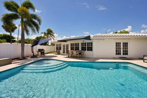 a swimming pool in front of a house at Salt Life Beach Cottage Sleeps 8 Heated Pool in Pompano Beach