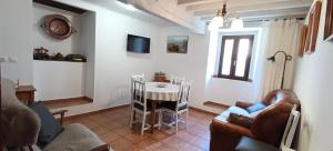 - un salon avec une table, des chaises et un canapé dans l'établissement Casa de la Cigüeña, à Candelario