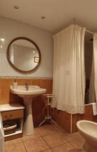 a bathroom with a sink and a mirror and a shower curtain at Casa de la Cigüeña in Candelario +17 photos