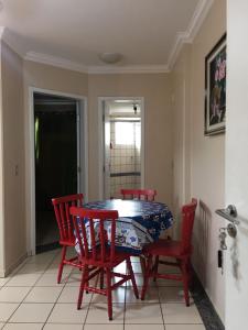 熱河市的住宿－Rio Quente - DiRoma，一间带桌子和四把红色椅子的用餐室