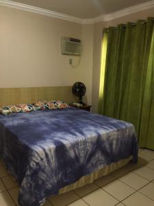 a bedroom with a blue comforter on a bed at Rio Quente - DiRoma in Rio Quente