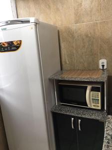 a refrigerator and a microwave on a counter in a kitchen at Rio Quente - DiRoma in Rio Quente