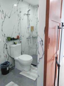 La salle de bains est pourvue de toilettes blanches. dans l'établissement 1BEDROOM Unit at Azure north With Netflix up to 6PAX, à San Fernando