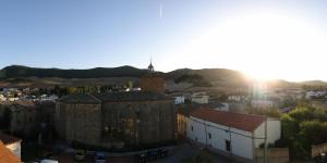 un antiguo edificio con una torre de reloj en una ciudad en Apartamentos Eneriz, en Enériz