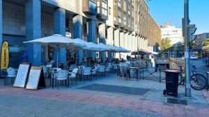 an outdoor cafe with tables and chairs and umbrellas at modern and neoclassical flat in Madrid