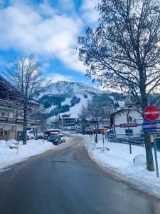 a snow covered street in a town with a mountain at Casa Enrico in Oberjoch