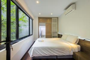 1 dormitorio con 1 cama y ventanas grandes en 22Sunny Housing Apartment, en Hanói