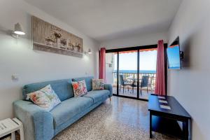 salon z niebieską kanapą i stołem w obiekcie Los Cristianos Achacay Bluesky Apartment w mieście Los Cristianos