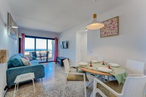 salon ze stołem i kanapą w obiekcie Los Cristianos Achacay Bluesky Apartment w mieście Los Cristianos