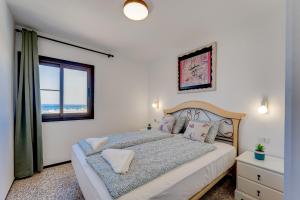 um quarto com uma cama grande e uma janela em Los Cristianos Achacay Bluesky Apartment em Los Cristianos