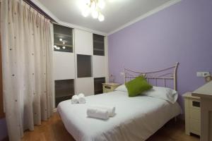 a bedroom with a white bed with towels on it at Corazón de Lemos in Monforte de Lemos