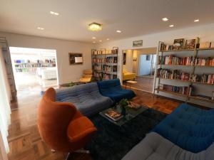 a living room with a blue couch and bookshelves at Casa francesa de Piraju in Piraju