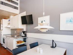 uma cozinha com mesa e cadeiras e uma televisão em 6 person holiday home in Fan em Fanø