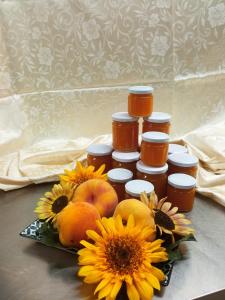 a group of jars of honey next to oranges and sunflowers at Tenuta le Cascine in Casalbuono +18 photos