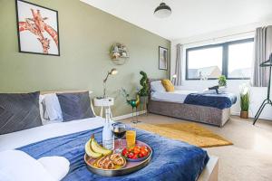 a room with two beds and a tray of food on a bed at Bewdley House - 5 Bedroom 3.5 Bathroom House - Free Parking, Private Garden, Super-Fast Wifi and Smart TVs by Yoko Property in Milton Keynes
