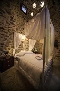 1 dormitorio con cama con dosel en una pared de ladrillo en Vilitsa Holiday House, en Pyrgi