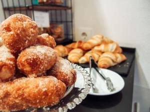 a pile of donuts on a table with plates of donuts at Zalamera BnB in Valencia