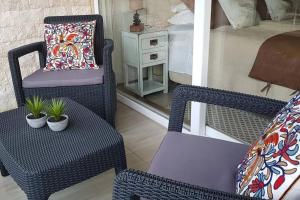a bedroom with two chairs and a bed and a chair with a pillow at Lindo y Equipado Departamento in Pucón