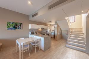 a kitchen and dining room with a table and a staircase at 3BR Family Villa in Sabina, El Gouna. Lagoon & Private Pool in Hurghada