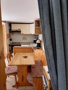 a kitchen with a wooden table and a curtain at Studio "Le Panpounet" in Les Contamines-Montjoie
