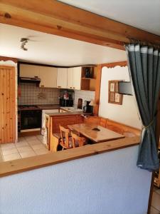 una cocina con una gran mesa de madera y sillas en Studio "Le Panpounet" en Les Contamines-Montjoie