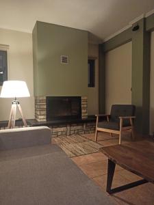 uma sala de estar com um sofá e uma lareira em Elatos Boutique MountainHouse em Karpenision