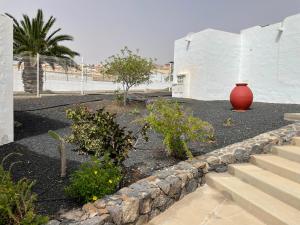 un jarrón rojo sentado en medio de un patio en Sun Beach 10, en Caleta de Fuste