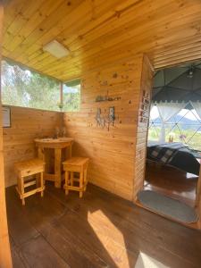 a wooden cabin with a bed and a table in it at Glamping El Refugio in Guatavita
