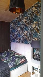 a bedroom with a bed and a wall with a blanket at Mała Garda in Brodnica Dolna