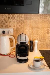 a coffee maker on a counter with a cup of coffee at Apartament Różana 21 in Poznań